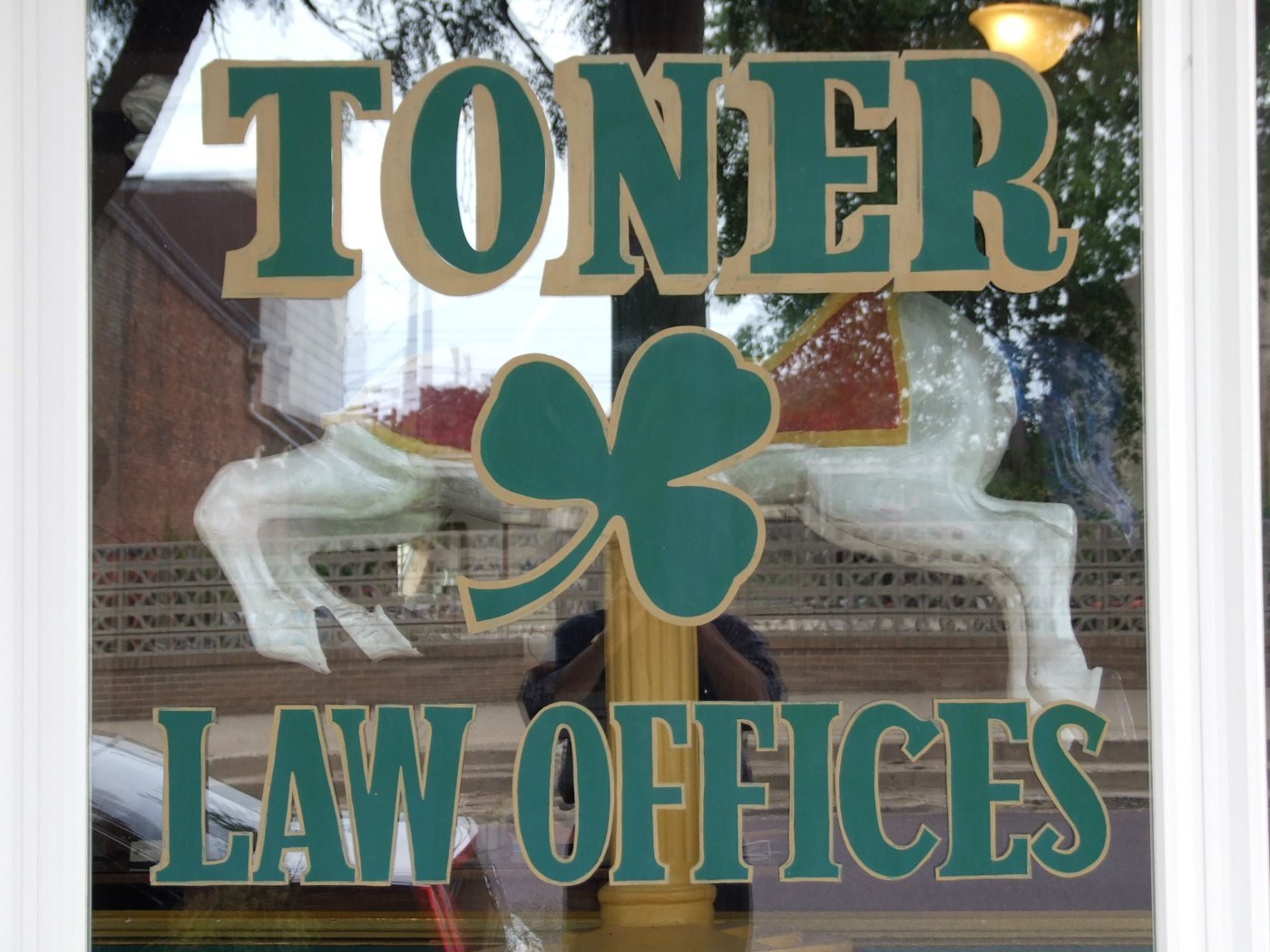The hand-painted Toner Law Offices window sign with a shamrock